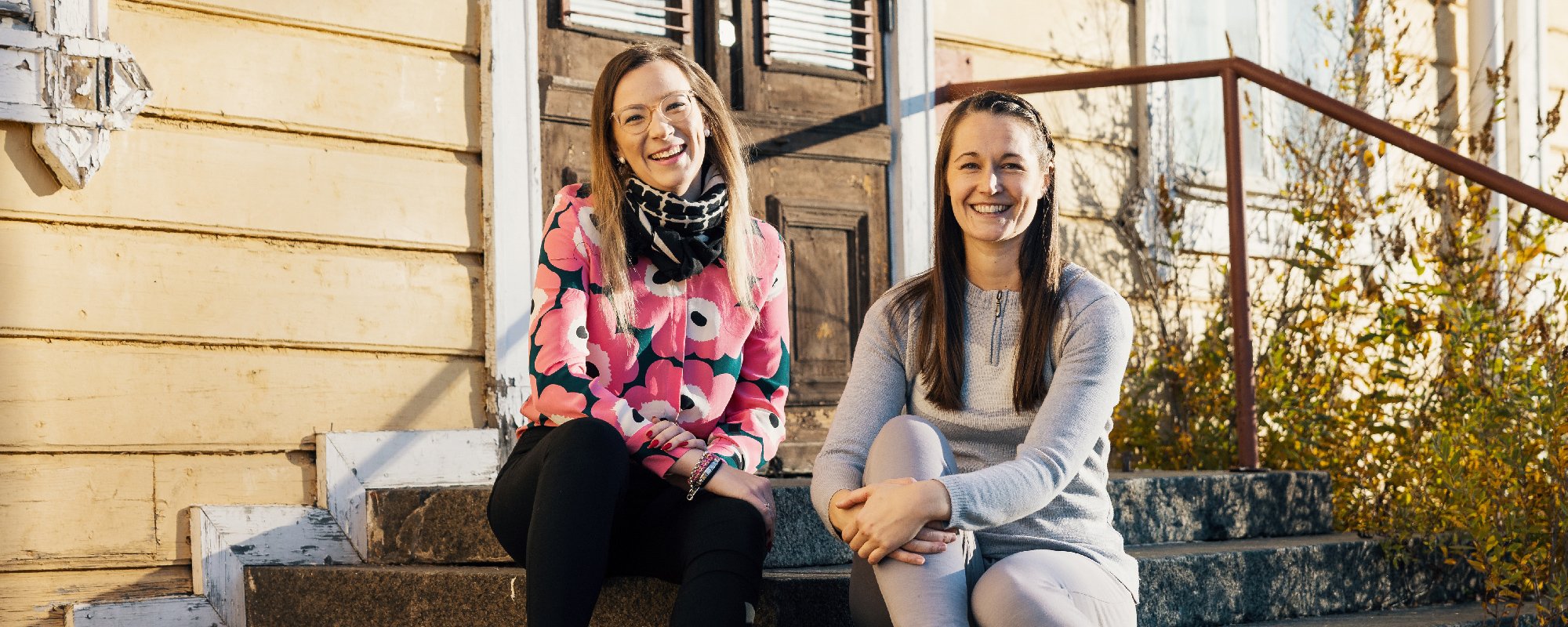 Jenna Tapola POP Pankki Lakeudesta ja Kalla Activen Jenni Valtari istuvat puutalon portailla