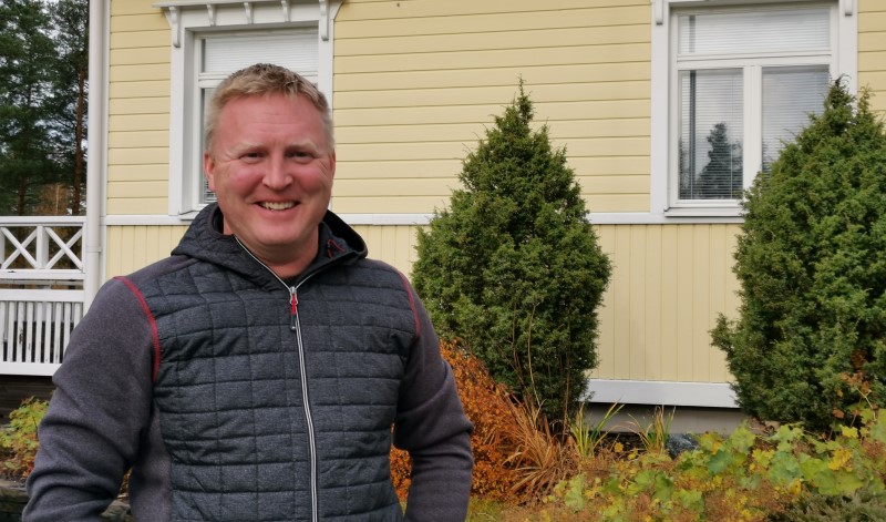 Tapio Lipponen seisoo keltaisen kotitalonsa edessä. 